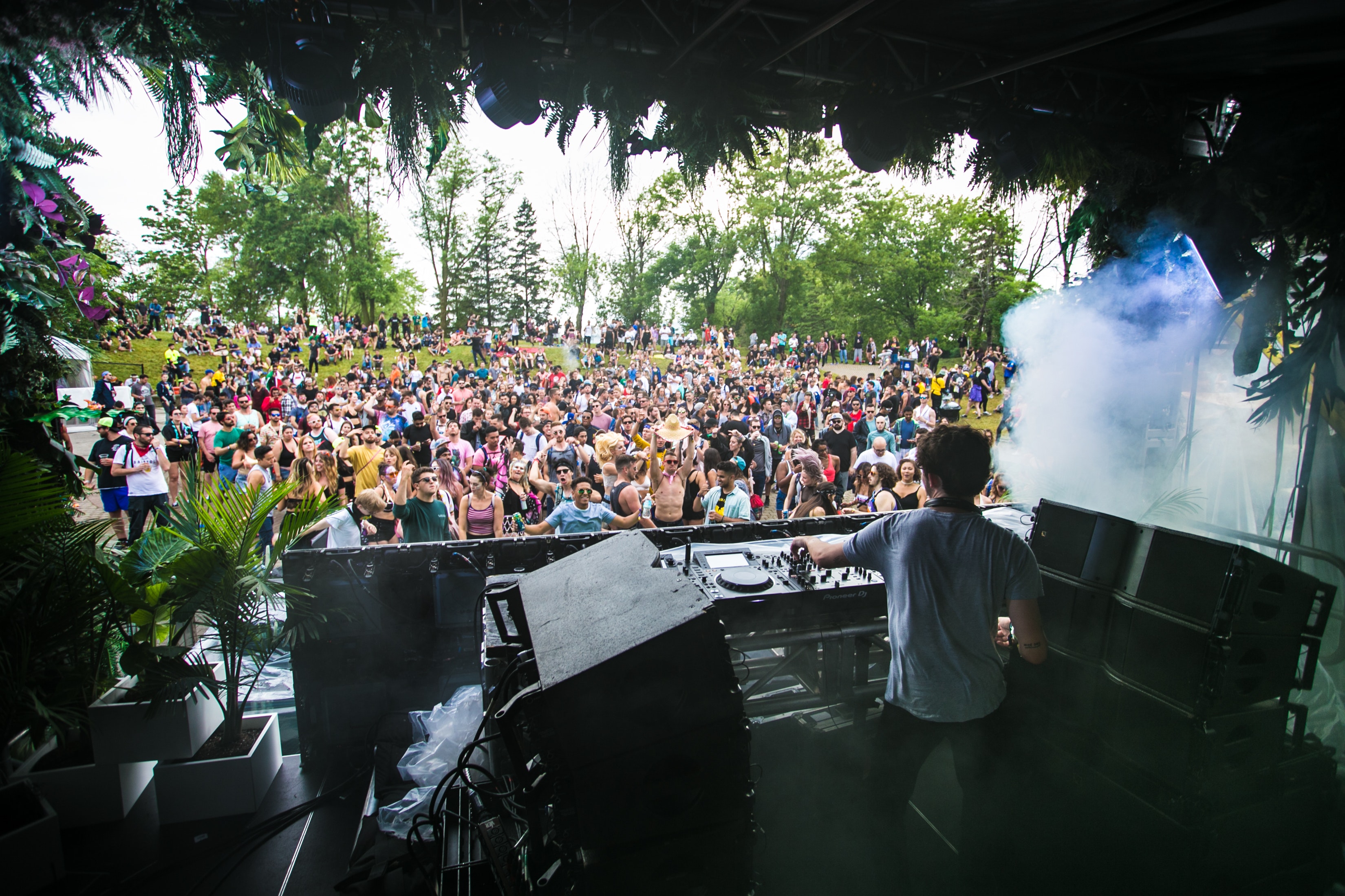 Dj playing to crowd of people at festival