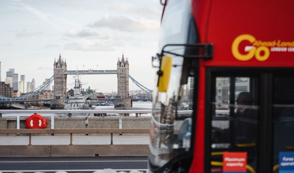 London bus in motion with Tower Bridge behind