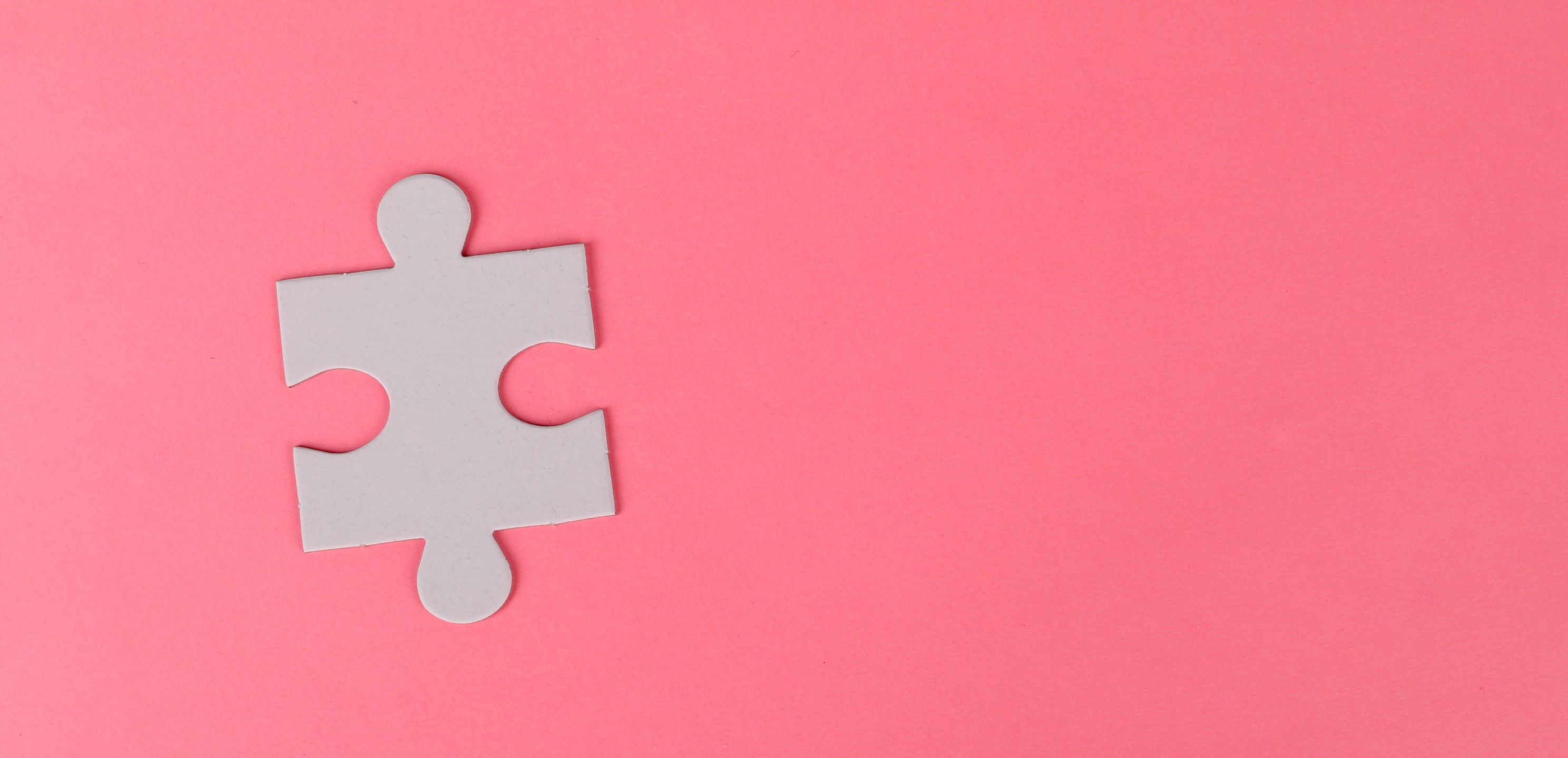 Puzzle piece on pink background