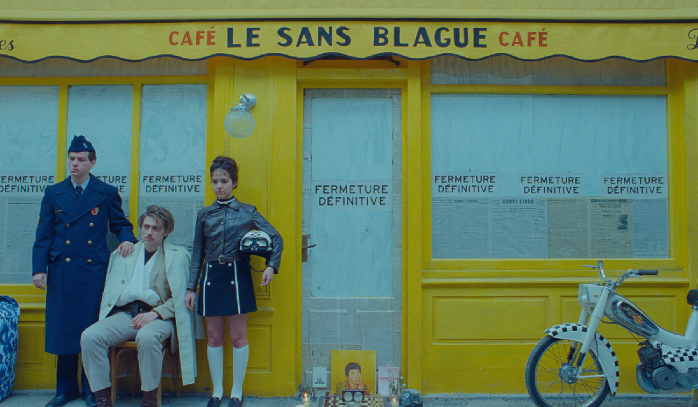 Men and women in military dress outside Le Sans Blague cafe