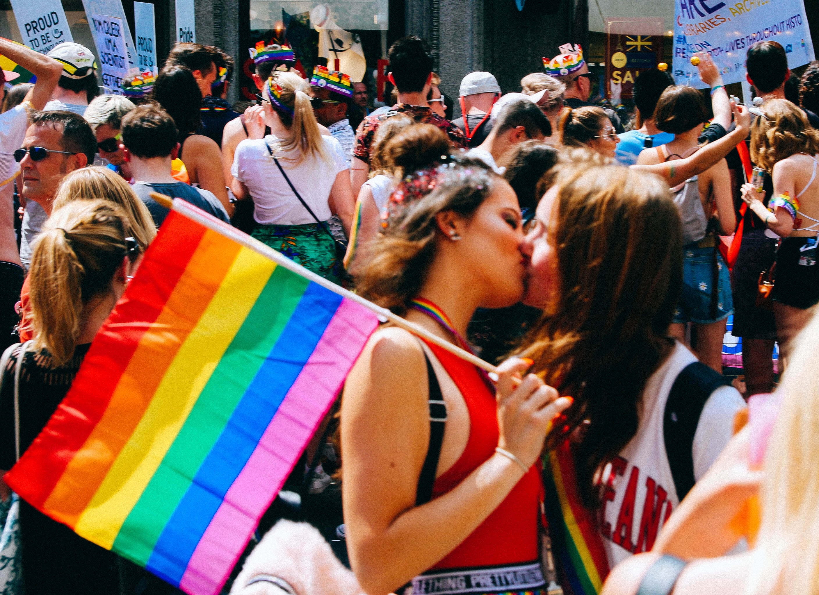 Couple kissing in crowd at Pride march